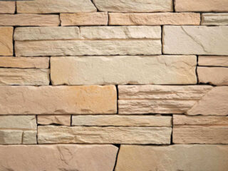 Voľne kladený fasádny obklad s prirodzenou štruktúrou v pieskovej farbe. Obklad Lámaný kameň F04 Mix